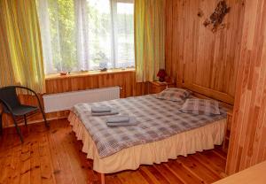 a bedroom with a bed and a chair in it at Pie Pifa in Pāvilosta