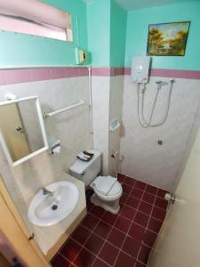 uma casa de banho com um lavatório, um WC e um chuveiro em Pacific Inn em Cidade Phuket