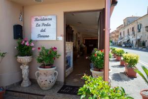 una entrada a una floristería con macetas en la acera en La Perla Del Tirreno, en Tropea