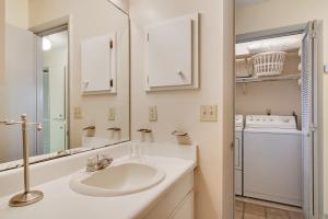a bathroom with a sink and a washer and dryer at Tarpon 10 in Panama City Beach +26 photos