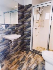 een badkamer met een wastafel en een douche bij Star Sukhumvit in Bangkok