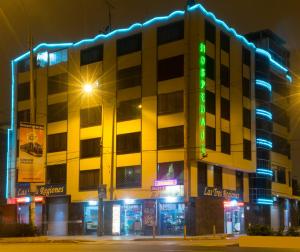 un edificio con letreros de neón delante de él en Hospedaje Las Tres Regiones en Lima