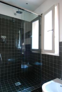 baño de azulejos negros con ducha y lavamanos en UR-NEST Piazza Maggiore, en Bolonia 14 fotos más