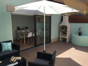 a living room with a table and an umbrella at Salty House in Furadouro