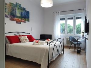Cette chambre comprend un lit avec des oreillers rouges et un bureau. dans l'établissement “I piccoli grani” delizioso BB vicino Vaticano, à Rome