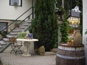 a patio with a table and a barrel and stairs at Ferienhäusel am Malerweg in Bad Schandau