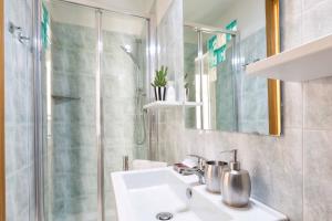 a bathroom with a sink and a shower at SorrentoVibes - Central Sorrento Apartment by PiazzaTasso&OldTown in Sorrento +17 photos