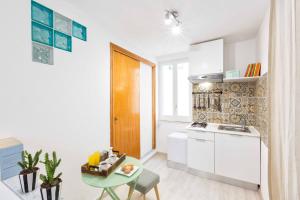 a kitchen with a small table and a kitchen with white cabinets at SorrentoVibes - Central Sorrento Apartment by PiazzaTasso&OldTown in Sorrento