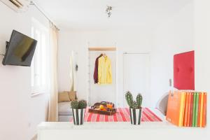 a living room with a table with plants and a tv at SorrentoVibes - Central Sorrento Apartment by PiazzaTasso&OldTown in Sorrento