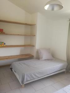 ein Schlafzimmer mit einem Bett, Regalen und einer Lampe in der Unterkunft Mas des gardies in Saint-Julien-de-Peyrolas