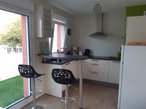 a kitchen with two chairs and a counter and a refrigerator at RESIDENCE APPART CENTRE VILLE LORIENT Calme Garage in Lorient