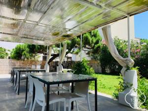 a patio with tables and chairs under a pergola at La Casa Del Tono in Milazzo