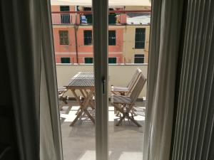balkon ze stołem i krzesłem wychodzącym przez okno w obiekcie Santa Marta Rooms - Vernazza w mieście Vernazza