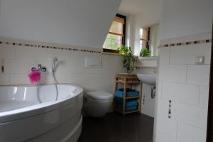 ein Badezimmer mit einer Badewanne, einem WC und einem Waschbecken in der Unterkunft Doppelzimmer Liliensteinblick 1.OG in Bad Schandau