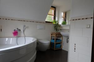 a bathroom with a tub and a toilet and a sink at Doppelzimmer Liliensteinblick 1.OG in Bad Schandau