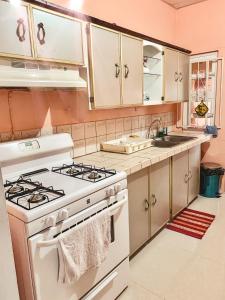 a kitchen with a stove and a sink at Apartment at Trincity Central Road in Port-of-Spain