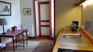 a kitchen with a sink and a table with a table at La Violiere in Rouziers-de-Touraine +12 photos