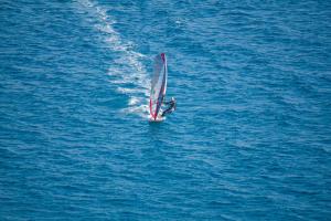 a person on a sail boat in the water at A White Cliffside Studio in Pag