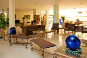 a lobby with couches and tables in a building at SBH Hotel Royal Mónica in Playa Blanca