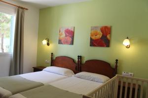 una camera con due letti e due quadri alle pareti di Villa RAQUEL a Cala'n Forcat Altre 5 foto