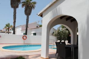 un patio con tavolo e sedie accanto alla piscina di Villa RAQUEL a Cala'n Forcat