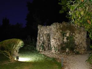 uma velha parede de pedra à noite em Appartamento con piscina immersa nel verde em Cascina
