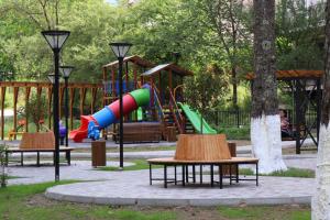 a playground with a slide in a park at Family Hotel Chino in Borjomi