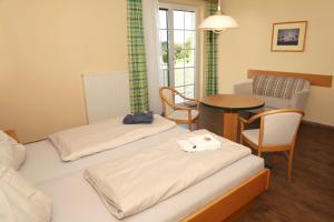 ein Hotelzimmer mit 2 Betten und einem Tisch in der Unterkunft Sonntagsberg Hof Familie Fiedler in Bad Waltersdorf
