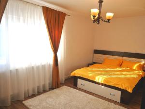 a bedroom with a bed and a large window at Apartament Atena in Petroşani