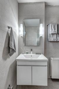 een badkamer met een witte wastafel en een spiegel bij Dream Garden Apartments Corfu in Kommeno