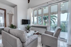 een woonkamer met 2 banken en een tv bij Dream Garden Apartments Corfu in Kommeno