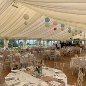 una tenda bianca con tavoli, sedie e palloncini di The Haven Hotel a Dunmore East