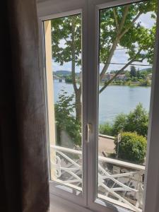une fenêtre ouverte avec vue sur le lac dans l'établissement Ô Petit Nice, à Neuville-sur-Saône