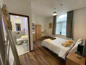 a bedroom with a bed and a bathroom with a sink at Self catering Skipton town centre apartment in Skipton
