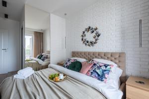 a bedroom with a bed with a plate of food on it at P&O Serviced Apartments Group Komputerowa in Warsaw