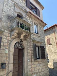 Edificio de piedra con puerta y balcón en Casa di Giulietta en Bomarzo