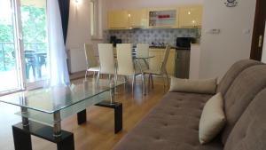 a living room with a glass table and a couch at Apartamenty Kornel in Pobierowo