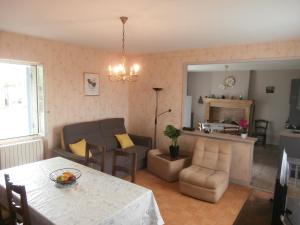 sala de estar con mesa de comedor y sala de estar en La grange de Tombeloly, en Clermont-de-Beauregard