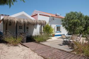 uma casa com um deque de madeira em frente em Casa da tertulia na Comporta