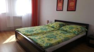 a bedroom with a bed with a flowery comforter at Apartamenty Kornel in Pobierowo