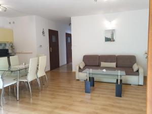 sala de estar con sofá, mesa y sillas en Apartamenty Kornel, en Pobierowo