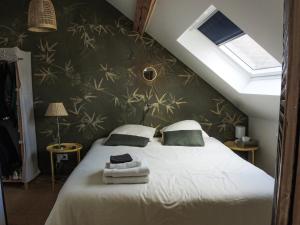 a bedroom with a bed with two towels on it at Les Chambres du Verger in Amiens