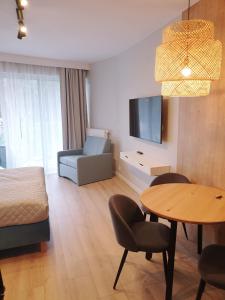 - un salon avec un lit, une table et un canapé dans l'établissement Albus 112 ApartPark, à Świnoujście