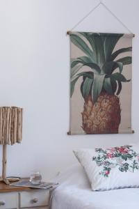 a bedroom with a pineapple painting on the wall at Casa da tertulia in Comporta