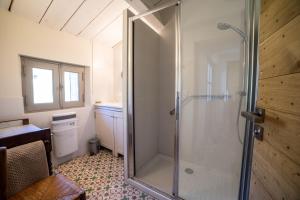 La salle de bains est pourvue d'une douche avec une porte en verre. dans l'établissement Domaine Les Perpetus, à La Tour-dʼAigues