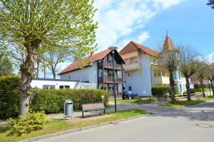 a building with a bench in front of a street at Apartment Strandstraße in Graal-Müritz
