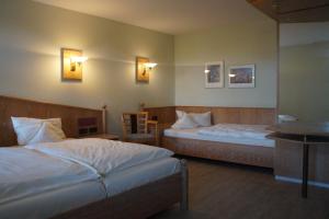 a hotel room with two beds and a table at Landhaus Bisping in Everswinkel