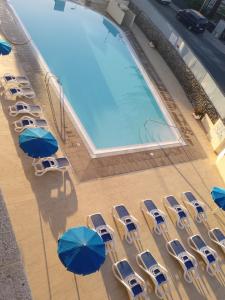 una vista aérea de una piscina con sillas y sombrillas en Apartamentos Montemar, en Playa del Inglés