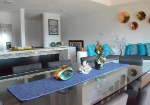 sala de estar con mesa de cristal y almohadas azules en Casa en Nuevo Altata con Alberca Privada, Villa del mar, en Altata