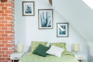 ein Schlafzimmer mit einem Bett mit vier Bildern an der Wand in der Unterkunft Au Zen Garden in Auxerre